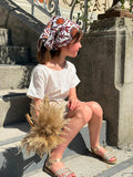Fille assise sur des marches en robe blanche